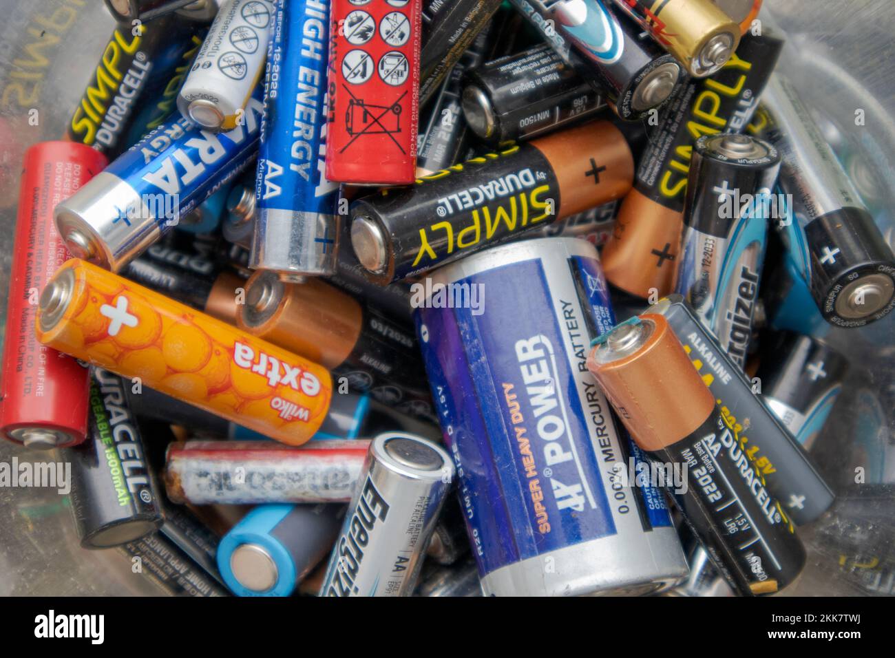 A closeup shot of a pile of used batteries in a battery recycling bin