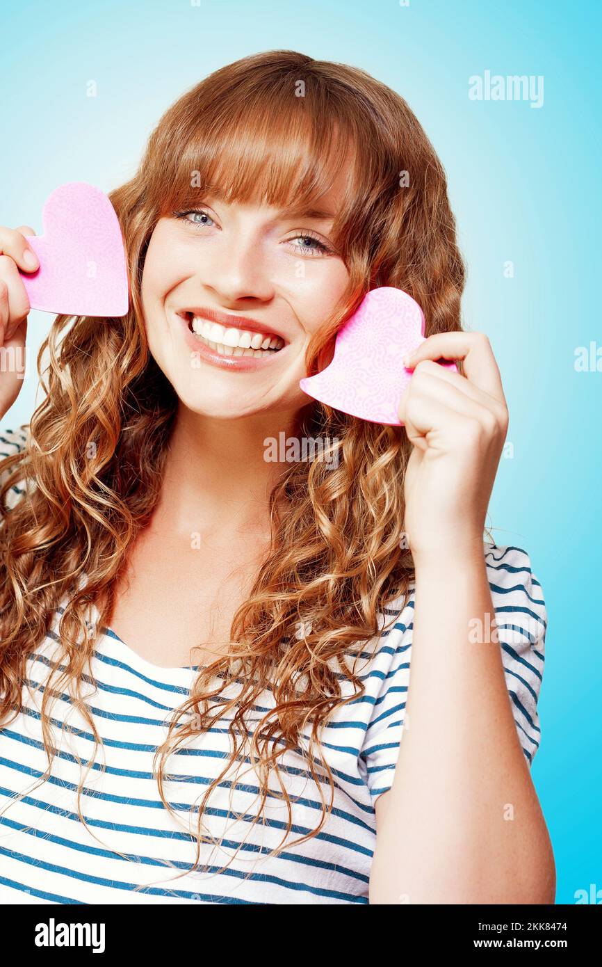 Beautiful Smiling Young Woman Holding Two Love Heart Note Pads In A Romantic Depiction Of Sending A Love Letter Stock Photo