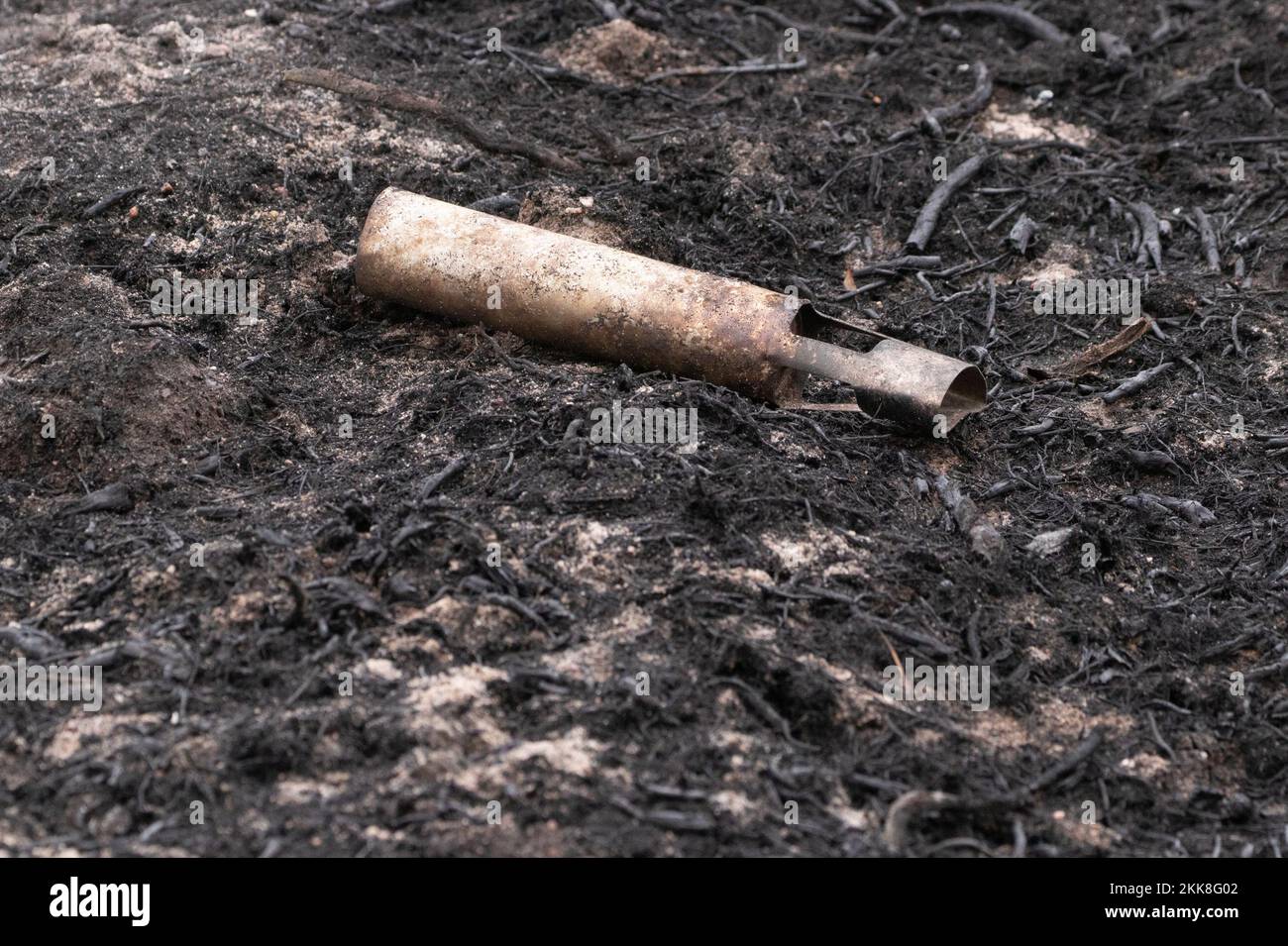 Discarded military munitions on burnt heathland. Hankley Common, Surrey, UK, Stock Photo