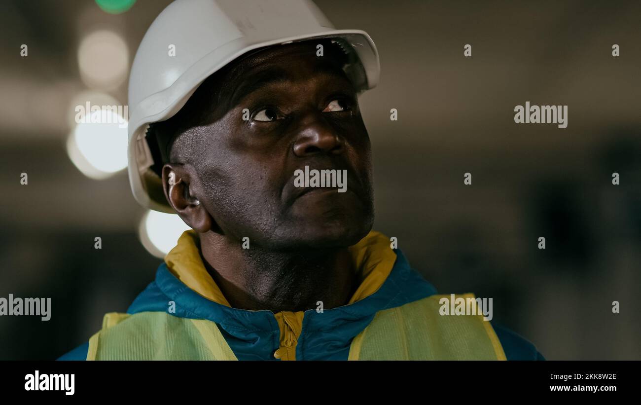Close-up serious focused mature man professional civil engineer in protective helmet inspects develops plan businessman builder experienced Stock Photo