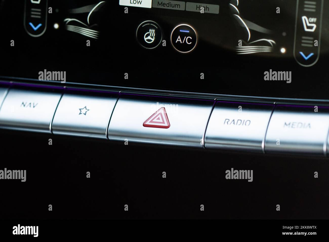 Red triangle hazard light button on car dashboard. Car media buttons