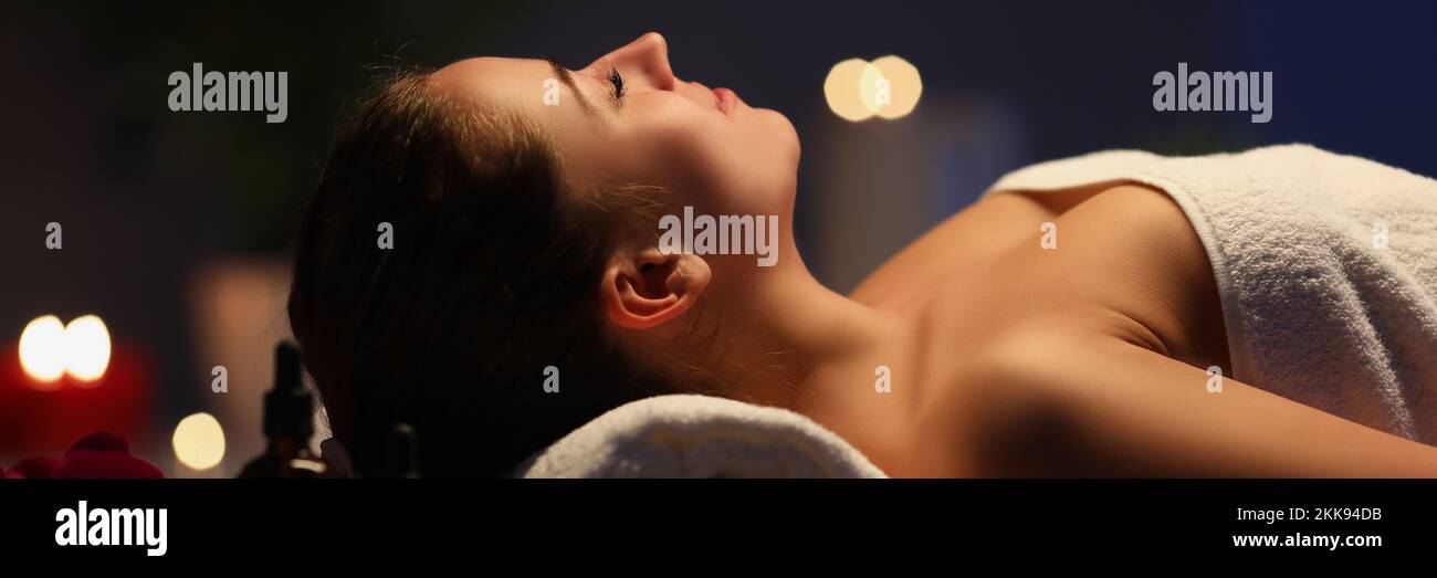 Relaxed girl lay with closed eyes on massage table in spa, wait for procedure to begin Stock Photo