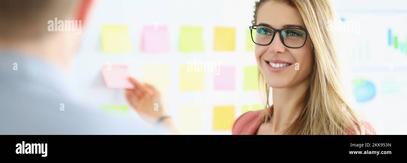 Businesswoman put colourful stickers on board, prepare presentation, set goals for next year Stock Photo