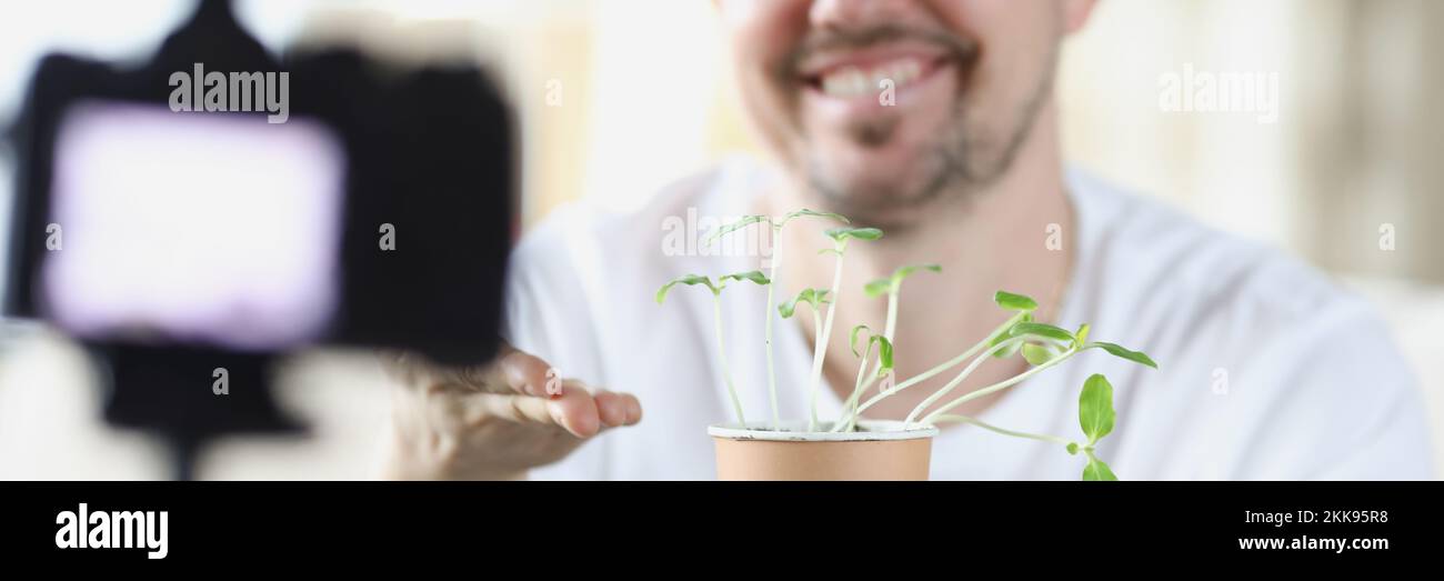 Middle aged man recording on video how he growing plants at home Stock Photo