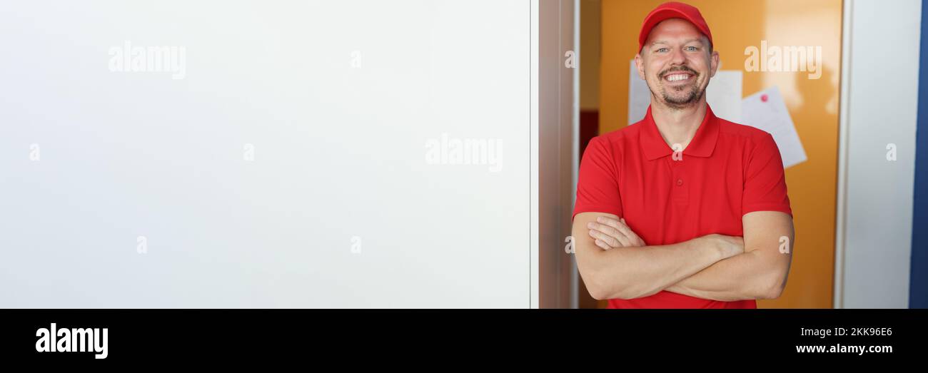 Happy man courier in red shirt and cap uniform, delivery worker Stock Photo