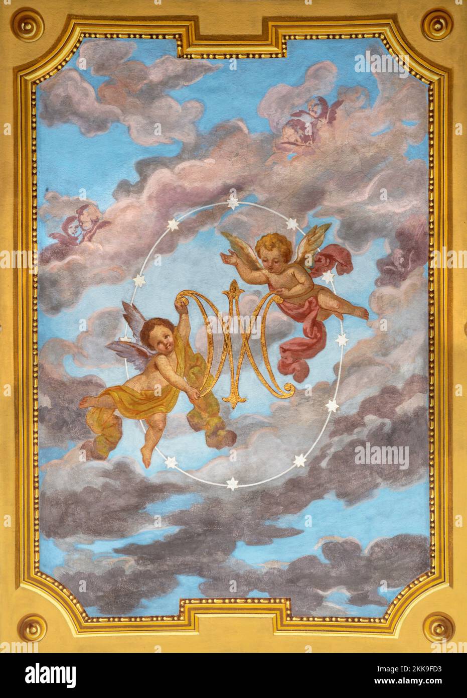 IVREA, ITALY - JULY 15, 2022: The ceiling fresco of angels with the marianic initials in the church Chiesa di San Salvatore by G. Silvestro (1914). Stock Photo
