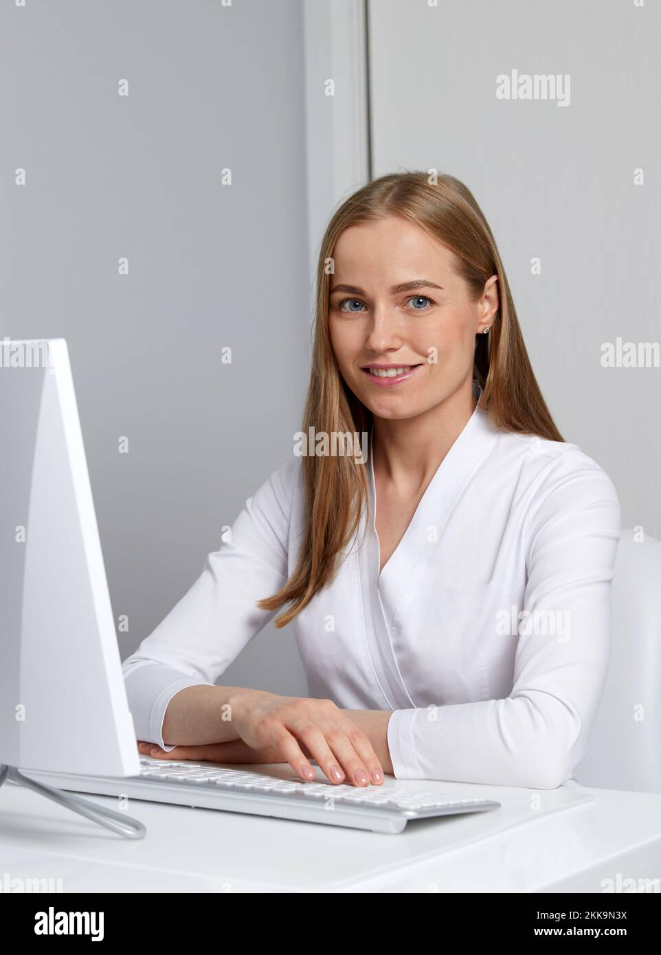 Smiling young female doctor working with her computer Stock Photo