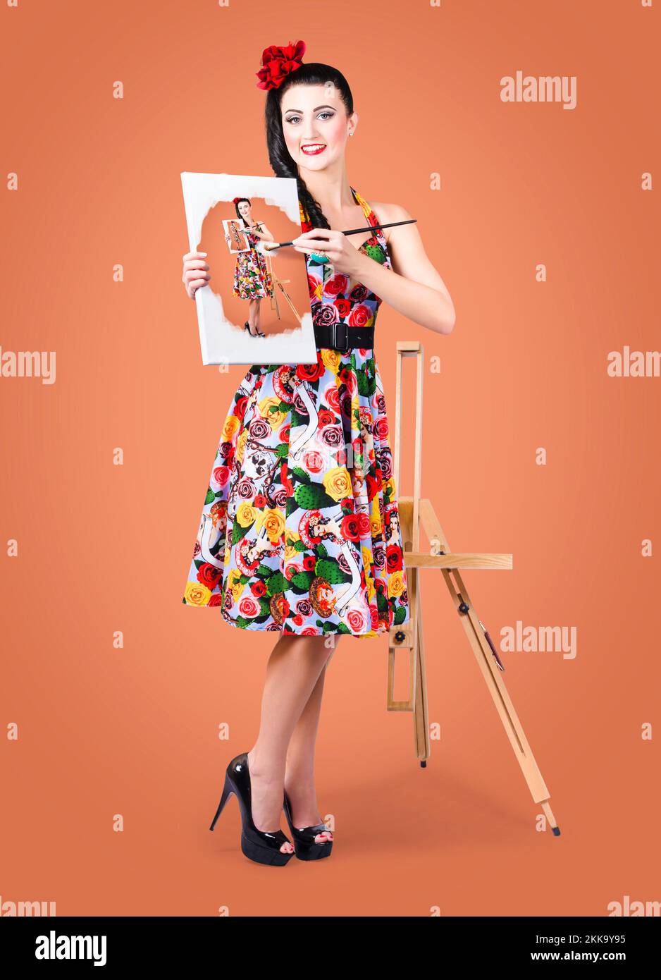 Beautiful female artist painting a self portrait with oil paint brush