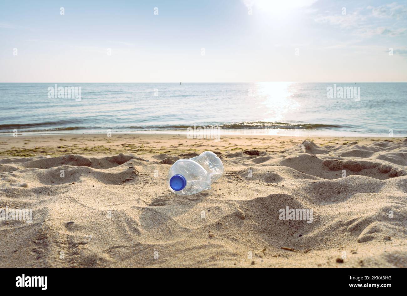 An empty, discarded plastic bottle on a sandy beach Stock Photo