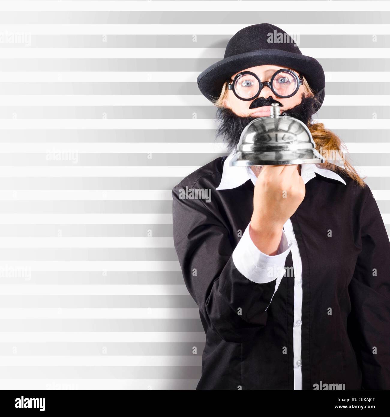 Square portrait of a comic business man holding large customer service bell on striped background Stock Photo