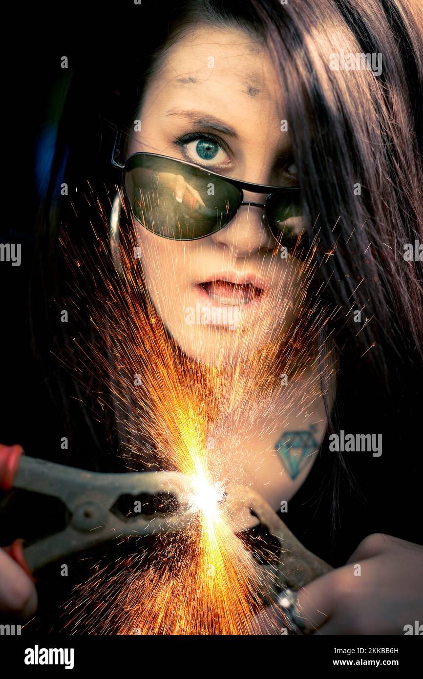 Sparks Fly When High Voltage Woman Ignites A Power Surge Of Energy By Putting Together Two Jump Start Leads Stock Photo