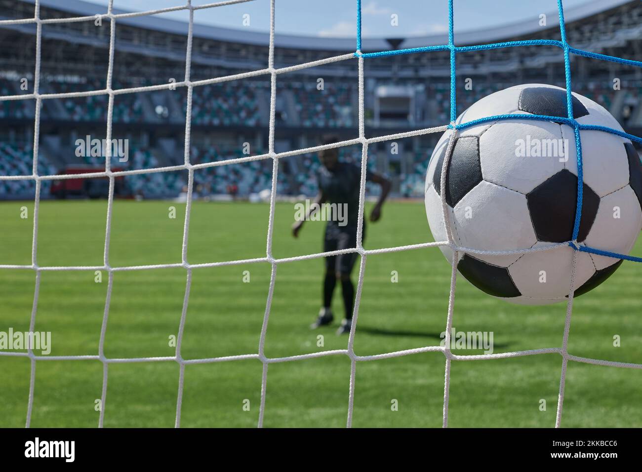 soccer player kicks the ball into the goal at the stadium Stock Photo