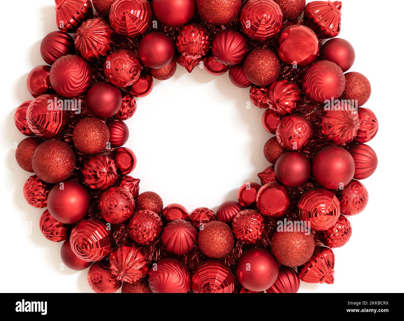Merry Christmas holiday greeting card or background without text.  Red Wreath made of red Christmas ornaments. Stock Photo