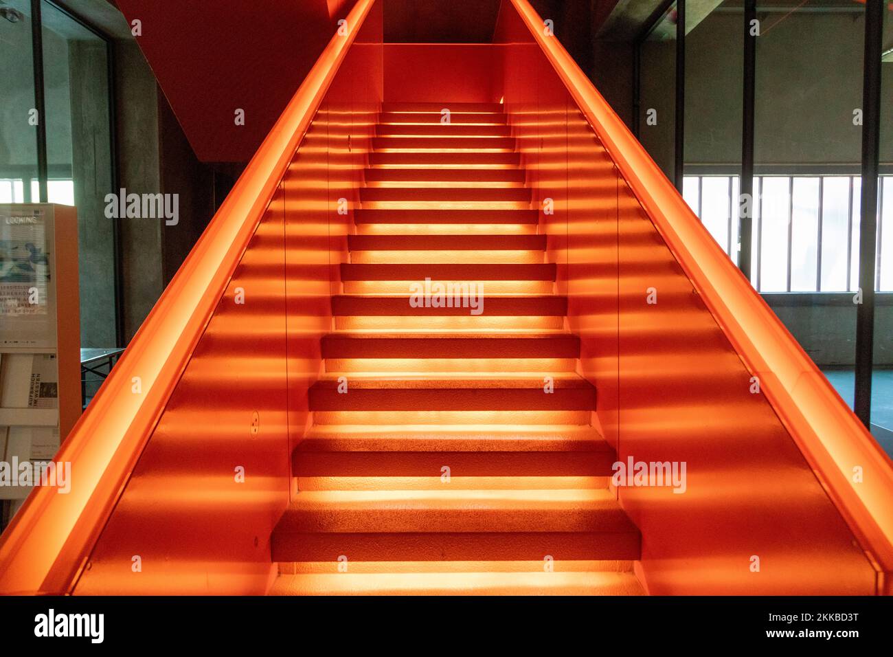 Essen, Germany - July 23, 2019:  Interior view of beautiful orange illuminated remarkable staircase is located at the entrance of Ruhr museum at Zeche Stock Photo