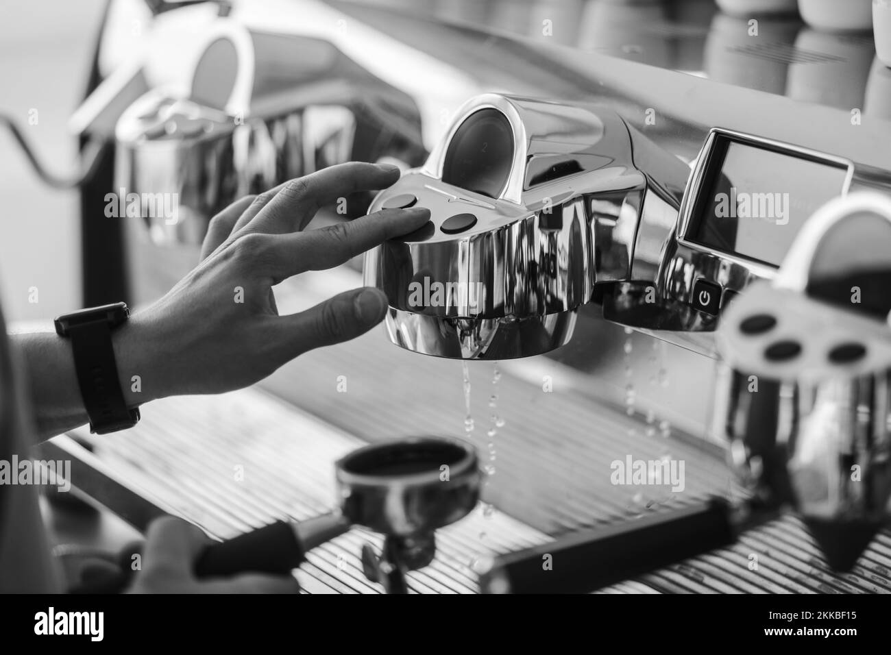 A black and white shot of espressomaking process near a coffeemaking