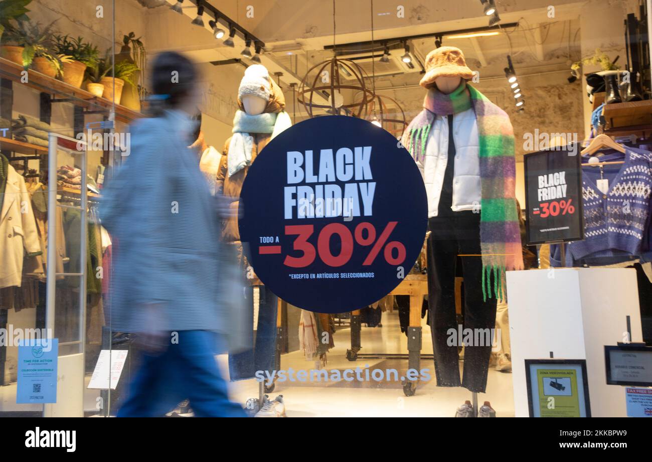 Palma, Spain. 25th Nov, 2022. A woman walks past a store on Black Friday in  downtown Palma on Mallora. A flood of special offers a few weeks before  Christmas, Black Friday has
