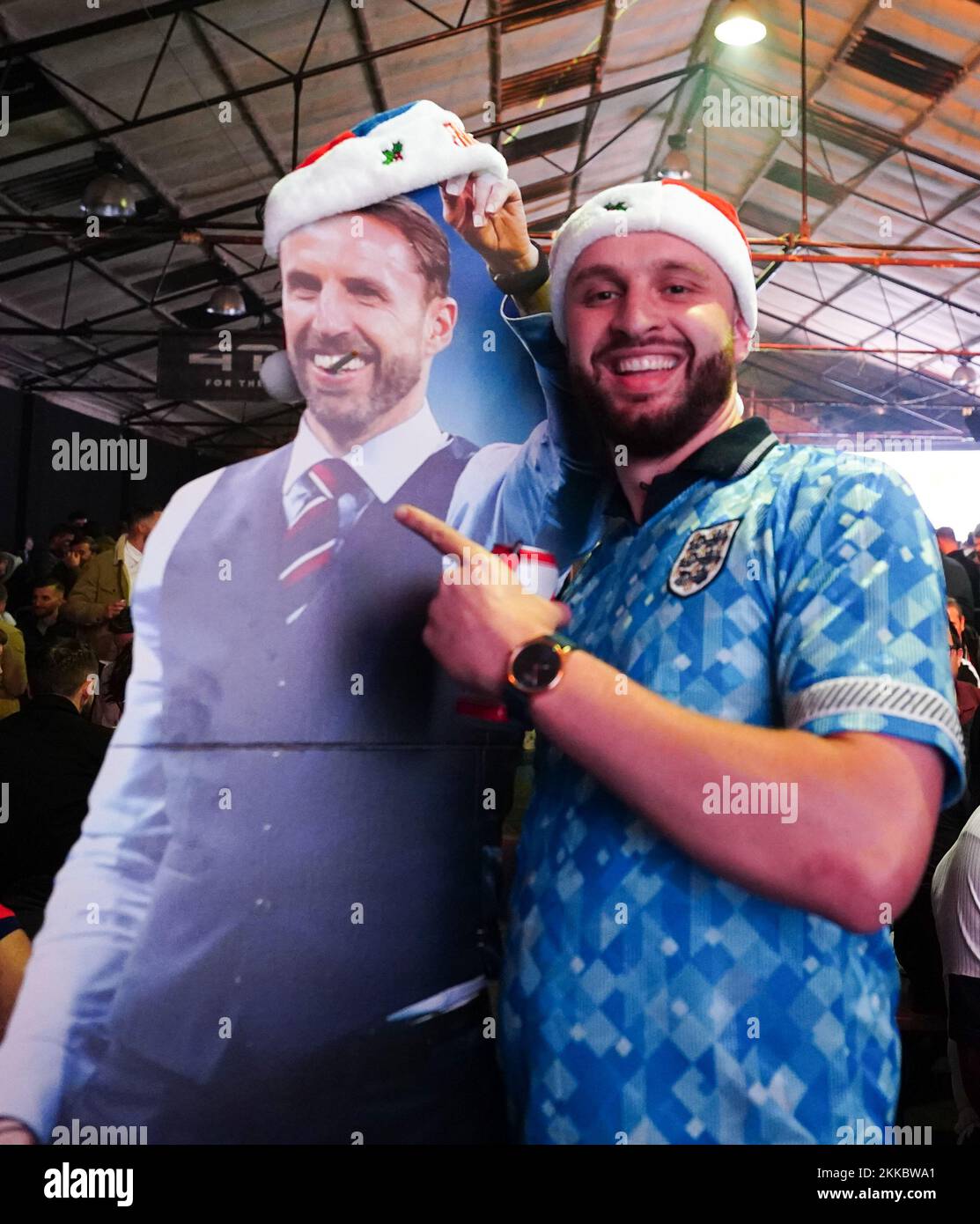 An England fan poses for a picture next to a cardboard cutout of