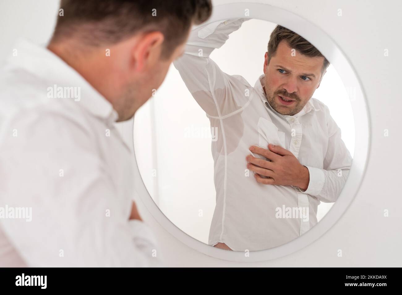 Man with hyperhidrosis sweating very badly under armpit Stock Photo - Alamy