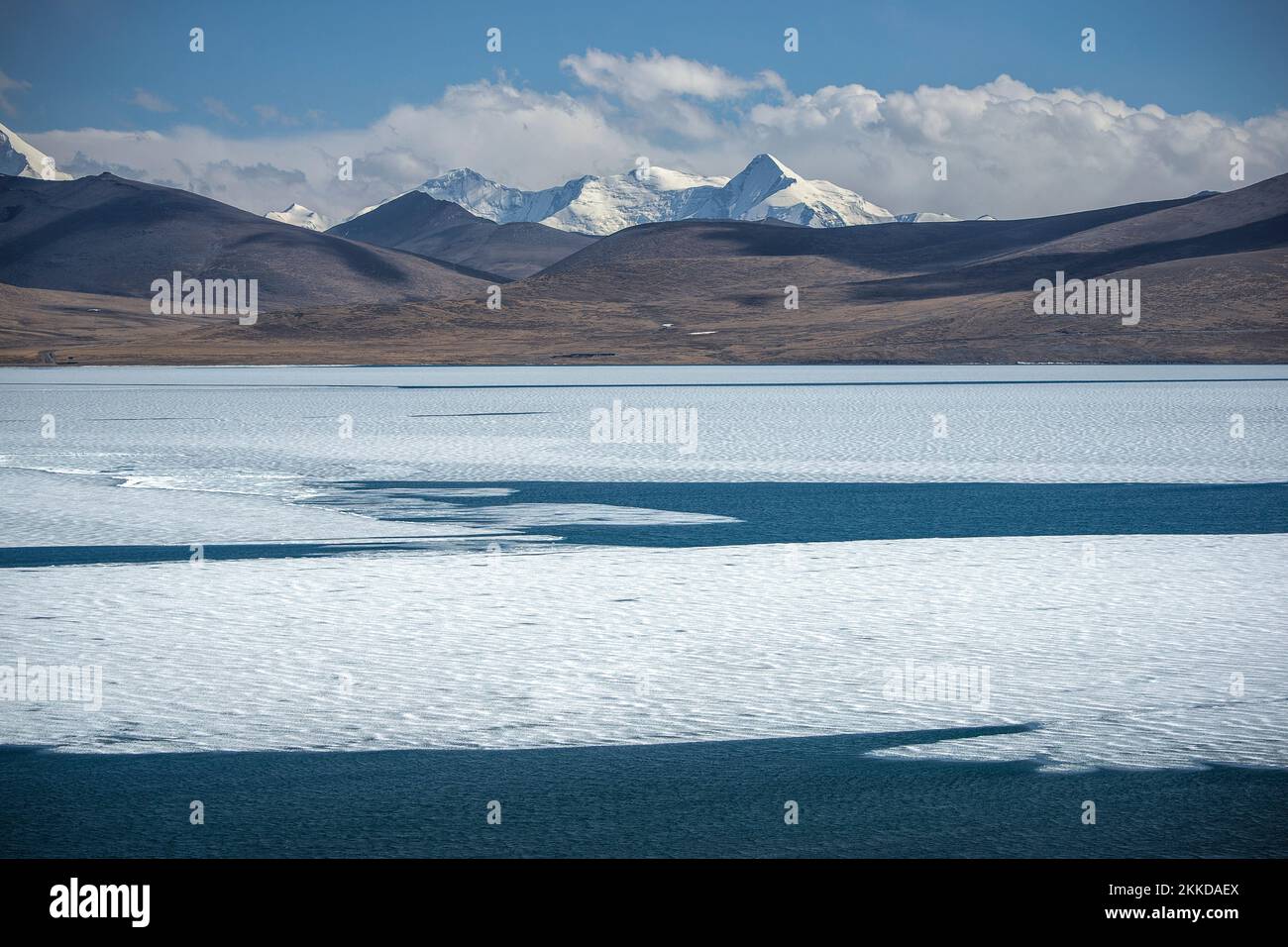 The blue-dominated view of the half-frozen Pumoyum Co Lake and the Himalayas in Shannan city, Tibet Stock Photo