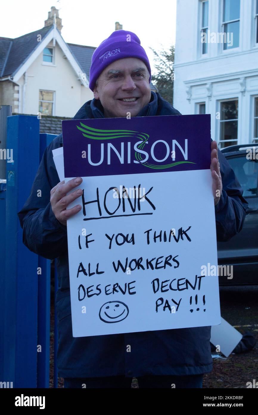 Cheltenham, UK. 25th Nov, 2022. 25th November 2022. Cheltenham, UK. A happy, smiling protester holding a sign to gain attention from passing cars alongside the university of gloucestershire at park campus Park campus The university and college lecturers union have begun industrial action on the grounds of pay and conditions in a dispute expected to last well into 2023. Credit: Pathos Images/Alamy Live News Stock Photo