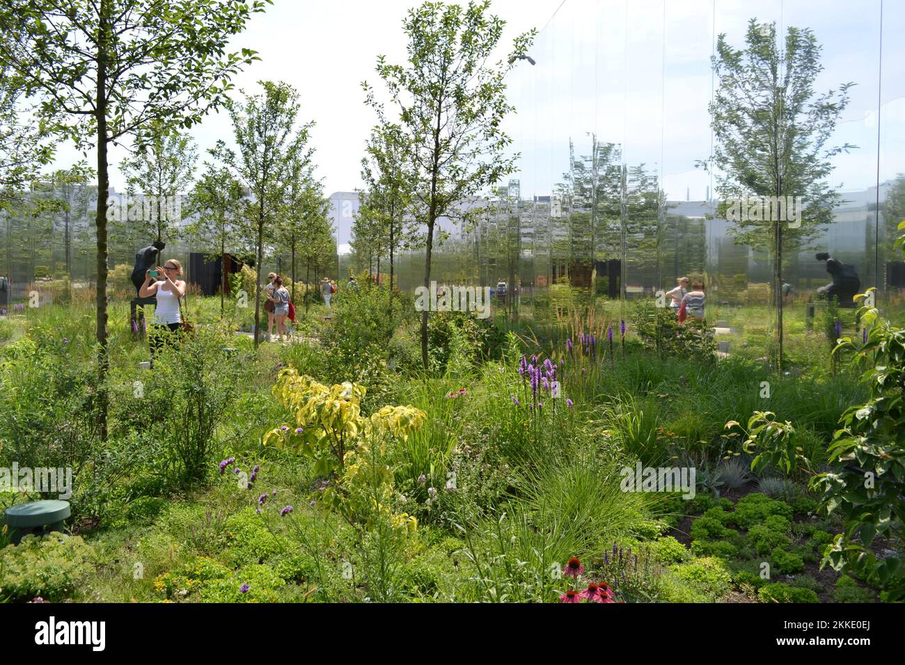 Panoramic view of the internal garden of the exhibition of the Polish pavilion at Expo Milano 2015 with a copy of a female statue, trees and flowers. Stock Photo