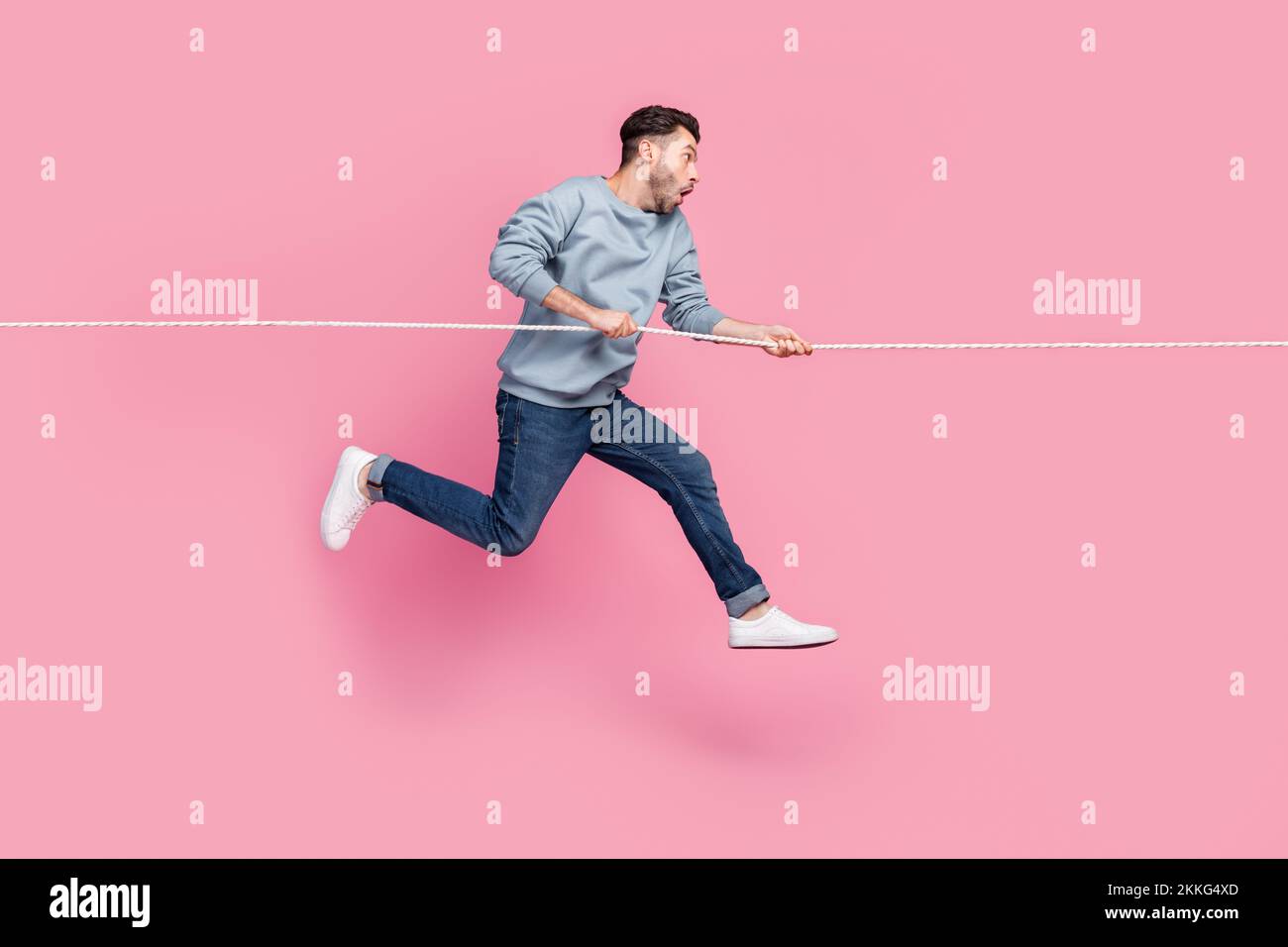 Profile side photo of impressed guy jump up pull strong string discount ...