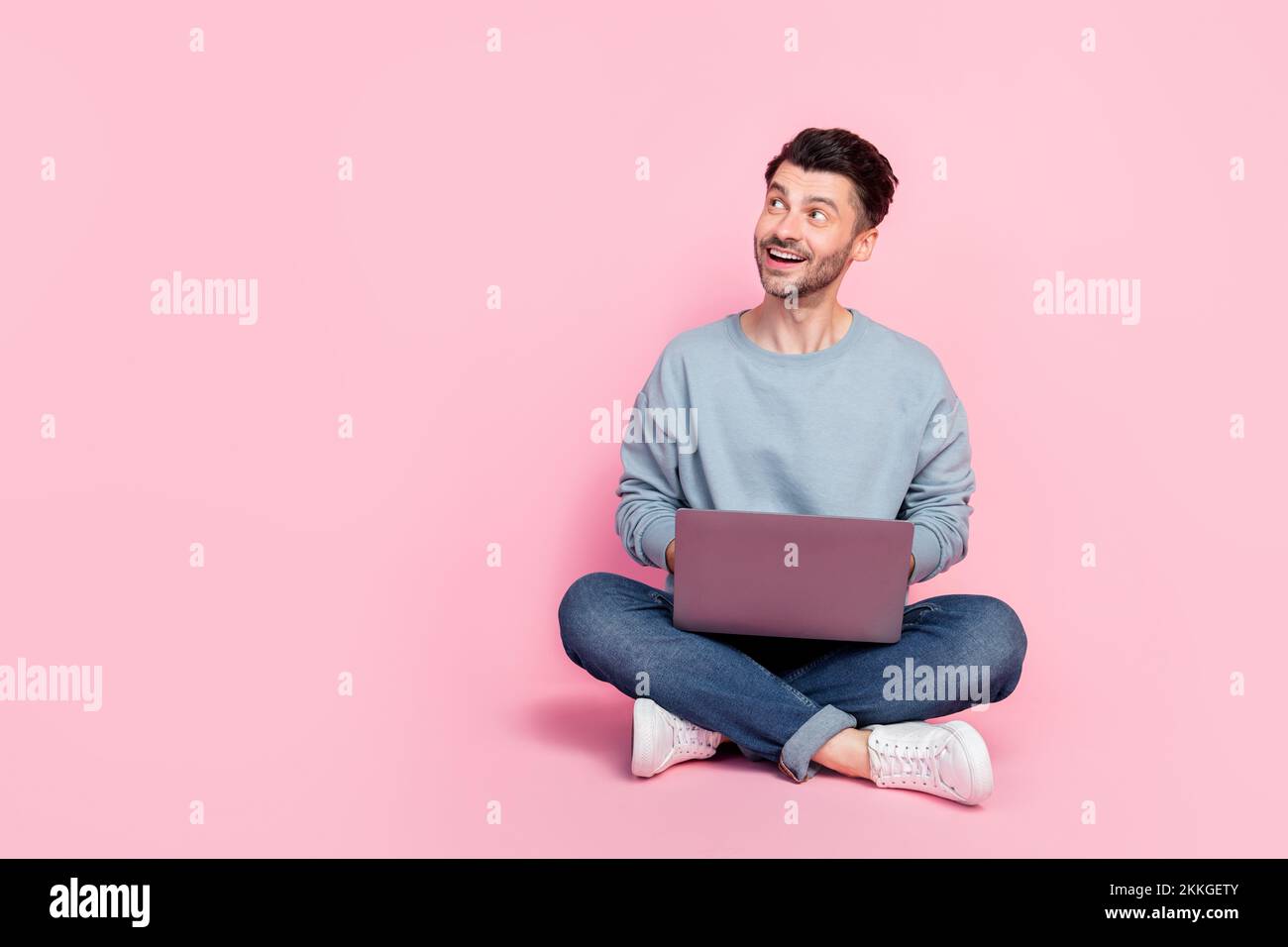 Full size photo of handsome young guy look empty space study remote university dressed trendy blue look isolated on pink color background Stock Photo