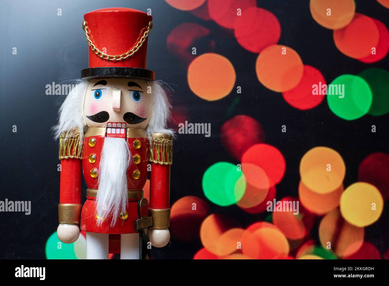 Muñeco Tradicional Navideño Cascanueces de Madera, con luces desenfocadas de fondo Stock Photo