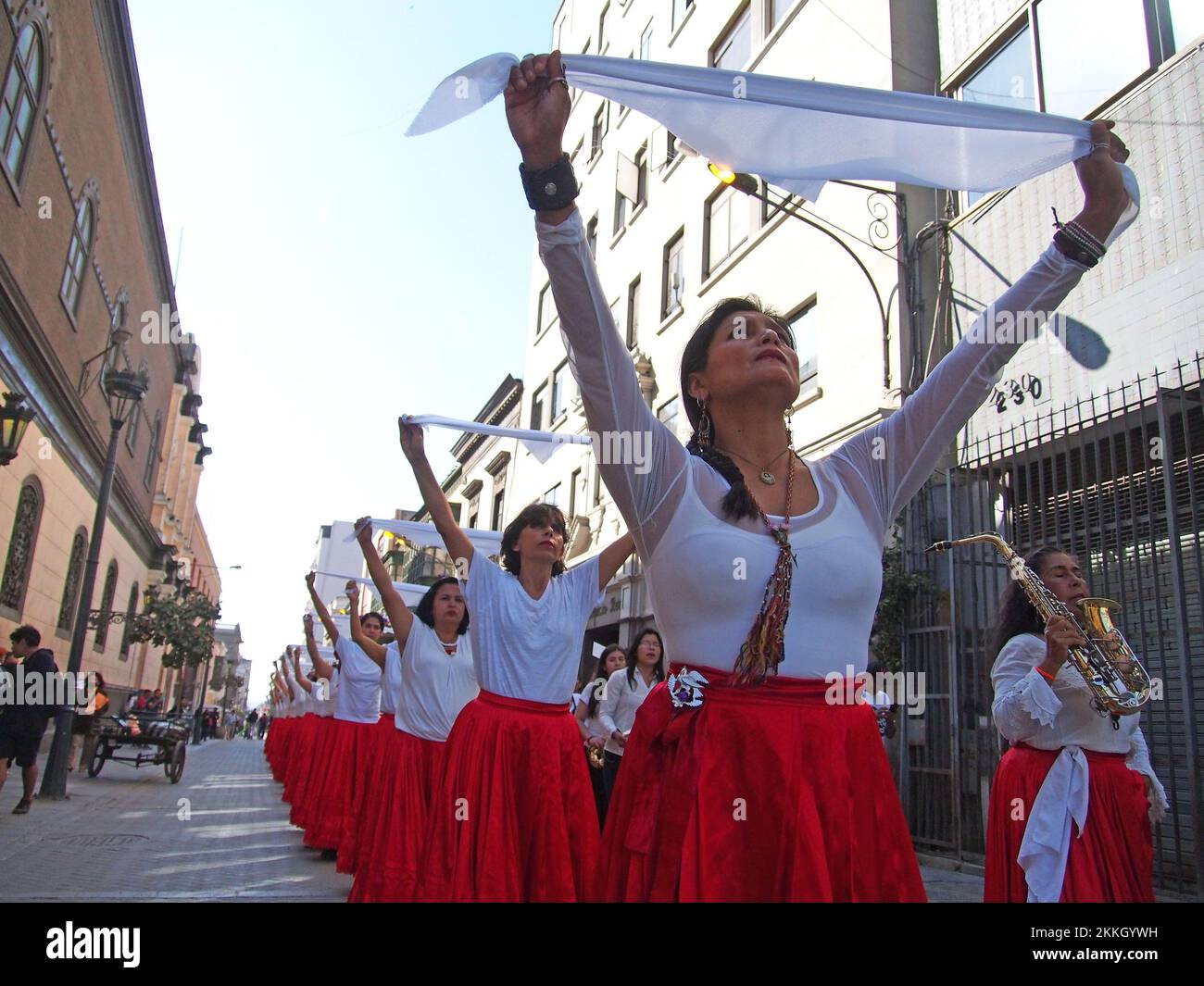 Girls waving white scarves when women from 'Red Tide' activist group performing in red skirts in the street of Lima as part of the activities of the International Day for the Elimination of Violence against Women, an event that is commemorated annually on November 25, the date on which the three Mirabal sisters (Patria, Minerva and María Teresa) were murdered. in the Dominican Republic on 1960. Credit: Fotoholica Press Agency/Alamy Live News Stock Photo