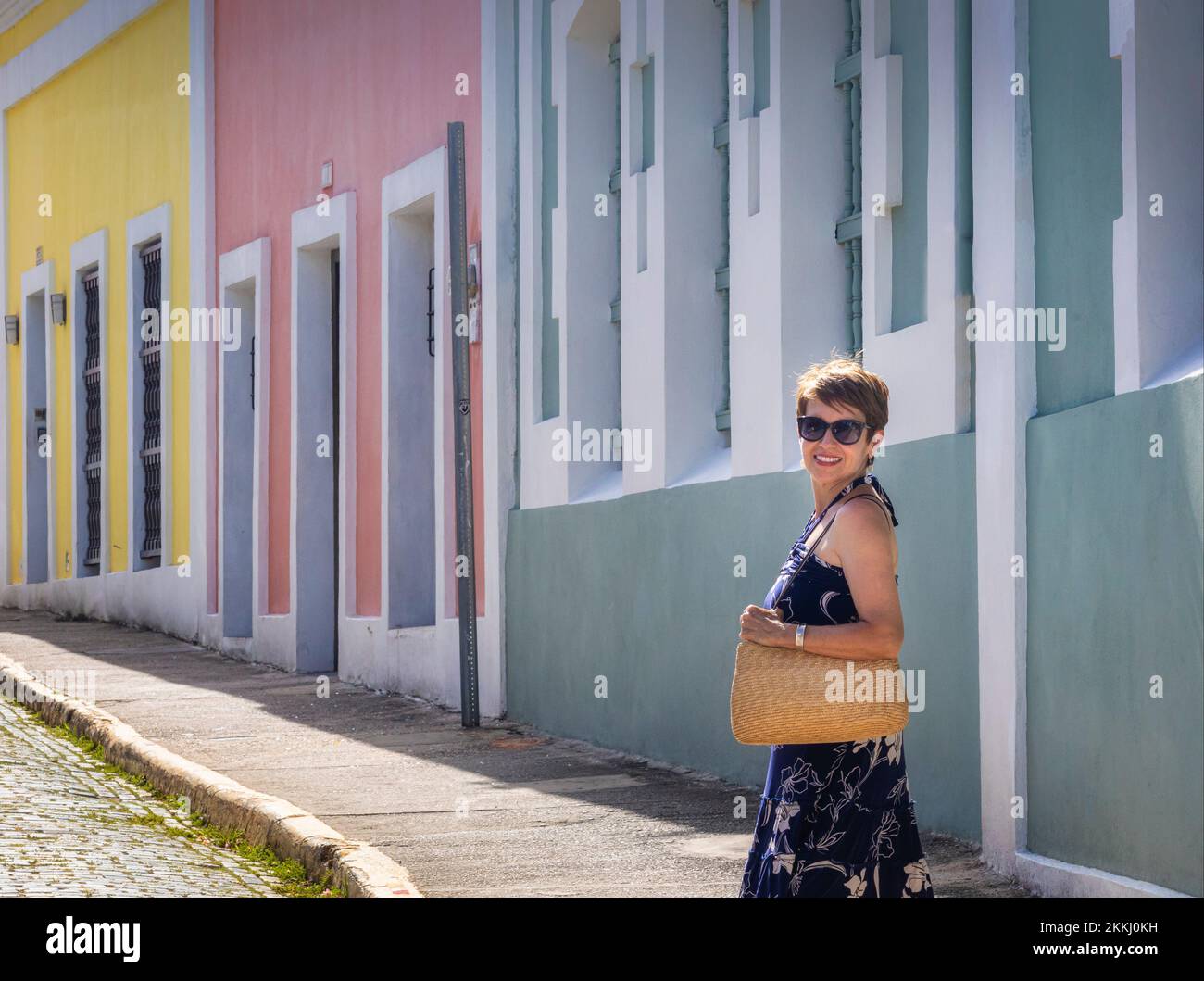 A female tourist strolls the streets of Old San Juan, on the tropical Caribbean island of Puerto Rico, USA. Stock Photo