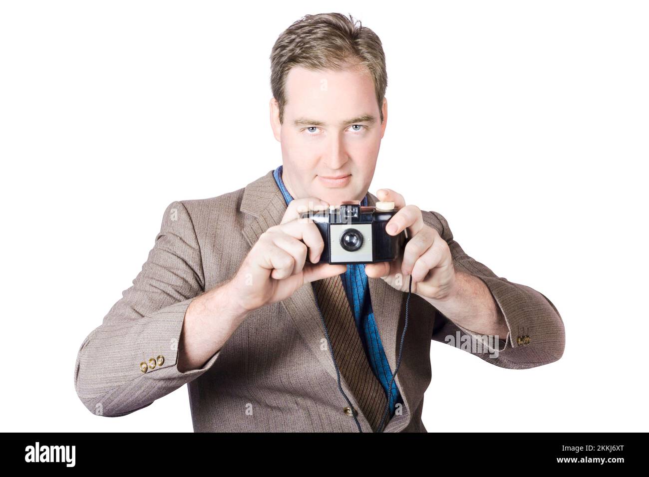 Isolated image of a man taking picture with 1950s film camera over white background. Fifties crime scene photographer Stock Photo