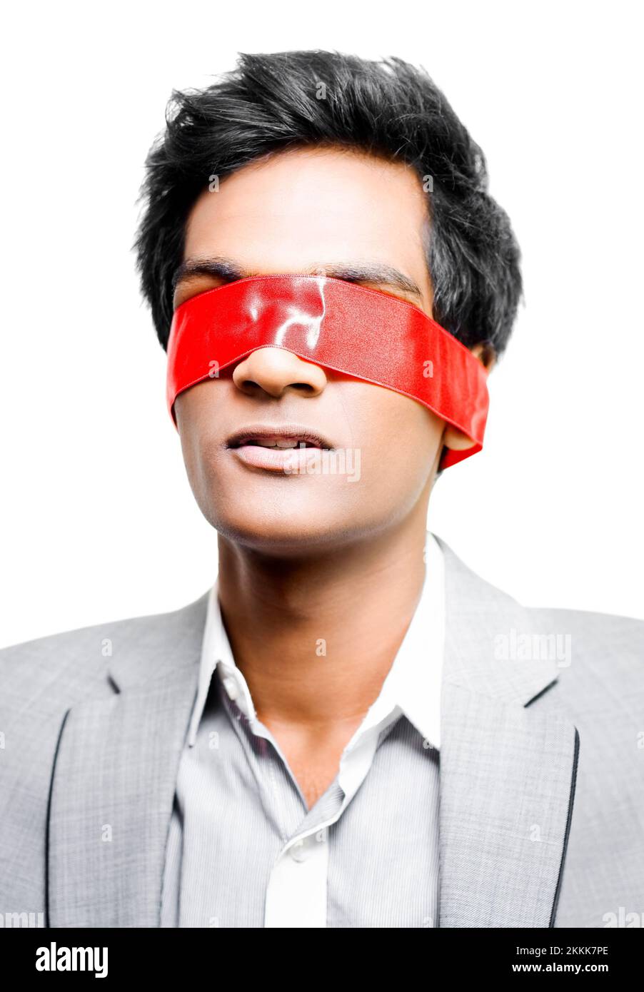 A young Asian business man has his eyes taped shut with a band of red tape conceptual of either Blinded by red tape due to unnecessary bureacracy or H Stock Photo