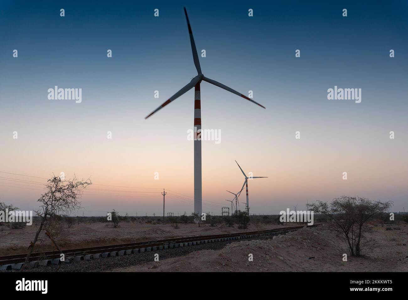 Pre dawn light in desert sky with Electrical power generating wind mills producing alterative eco friendly green energy for consumption by local peopl Stock Photo