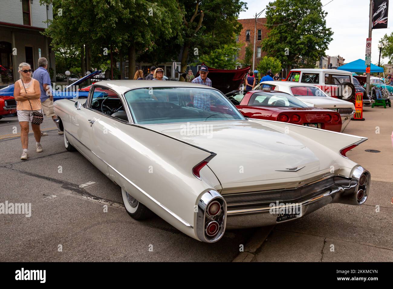 A classic white 1960 Cadillac Series 62 coupe on display at a car show