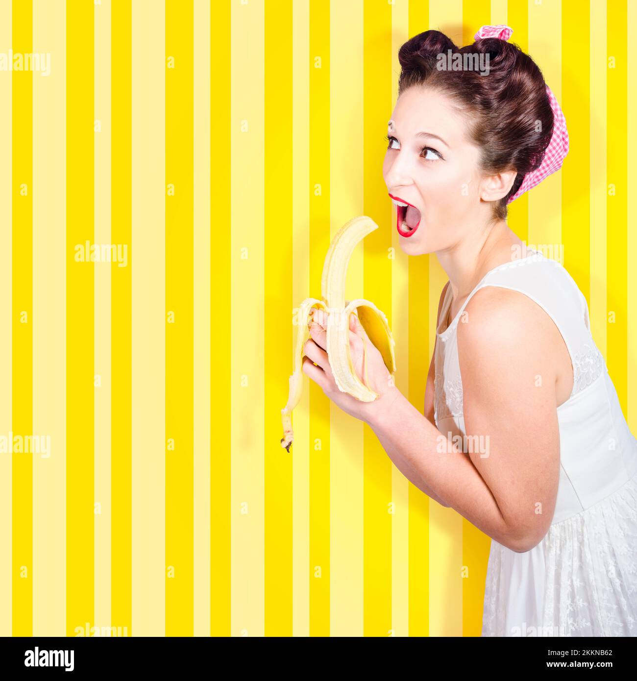 Comical retro housewife eating banana in 1950s revival fashion on