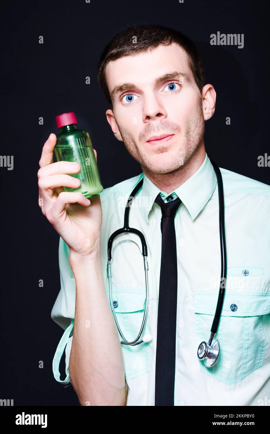 General Practitioner Doctor Holding Cold And Flu Liquid Cough Medicine On Dark Studio Background