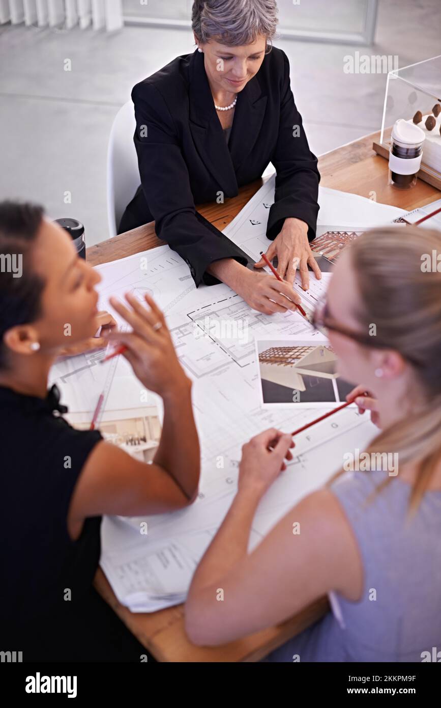 Its all about the details. A group of female architects working together on a project at a conference table. Stock Photo