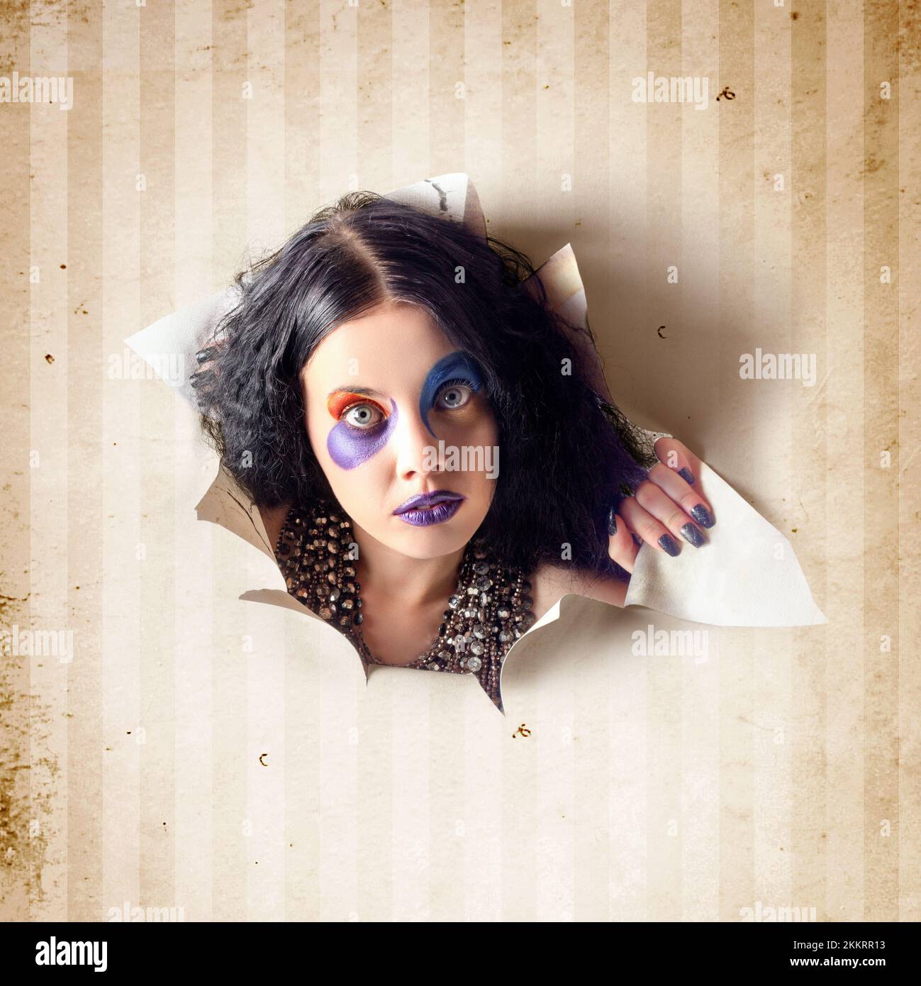 Surprised face of an attractive young jester girl breaking out of