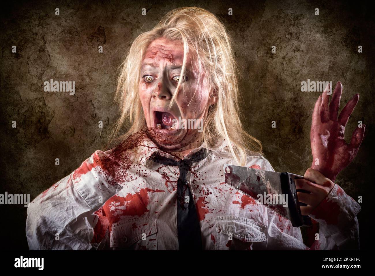 Halloween gore photo of a dead female zombie with bloody saw and amputated  hand. Slasher concept Stock Photo - Alamy