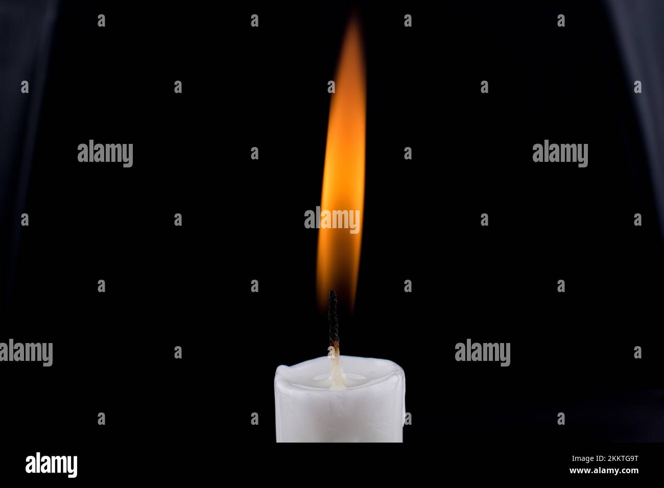 Burning white candle on a black background Stock Photo - Alamy