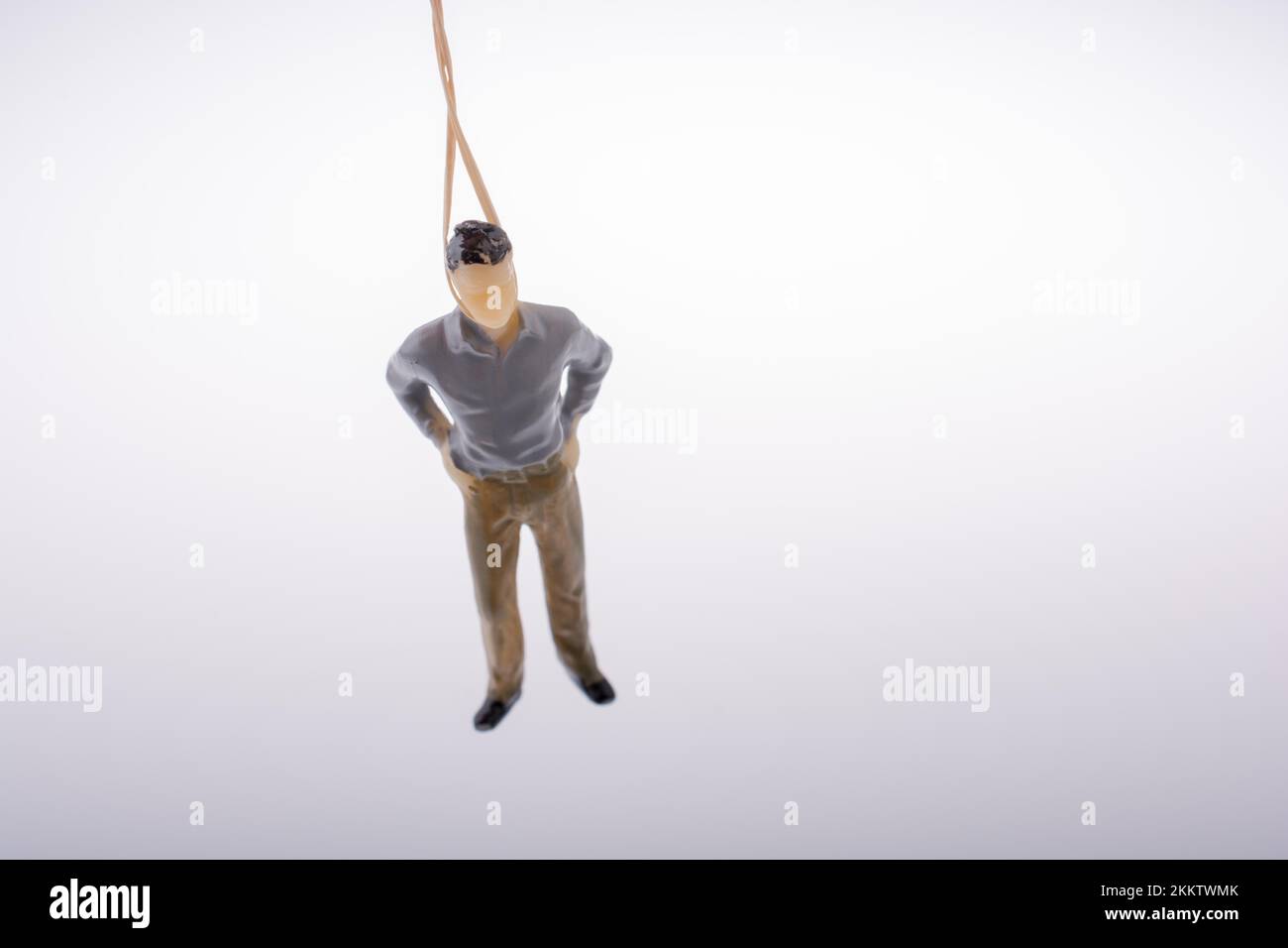 Man figurine tied with aa rope on a brown backgorund Stock Photo
