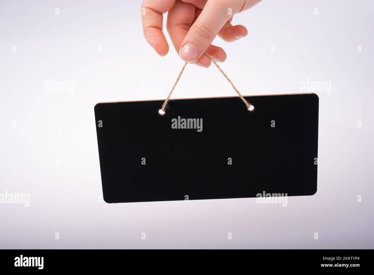Rectangular shaped black notice board in hand on white background Stock