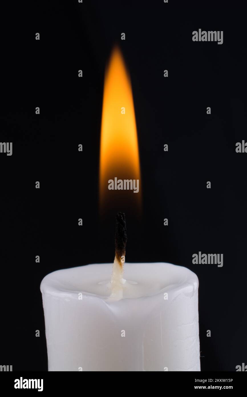 Burning white candle on a black background Stock Photo - Alamy