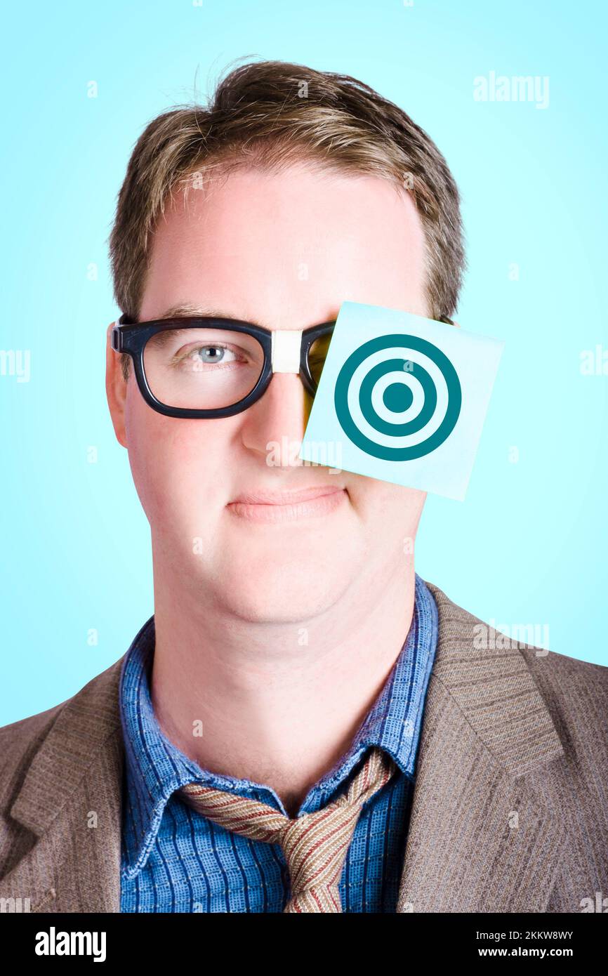 Ambitious nerd businessman wearing paper note with bullseye target on face. Aims and goals Stock Photo