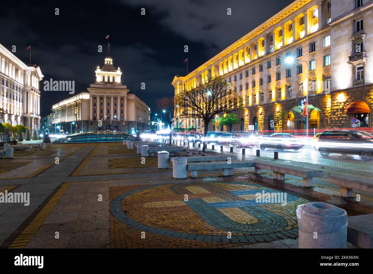 Night scene of tram in traffic at crossing with lighttrail Stock Photo