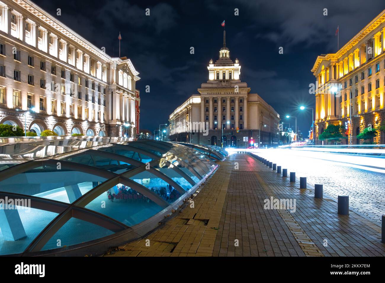 Night scene of tram in traffic at crossing with lighttrail Stock Photo