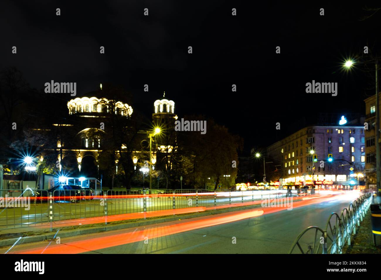 Night scene of tram in traffic at crossing with lighttrail Stock Photo