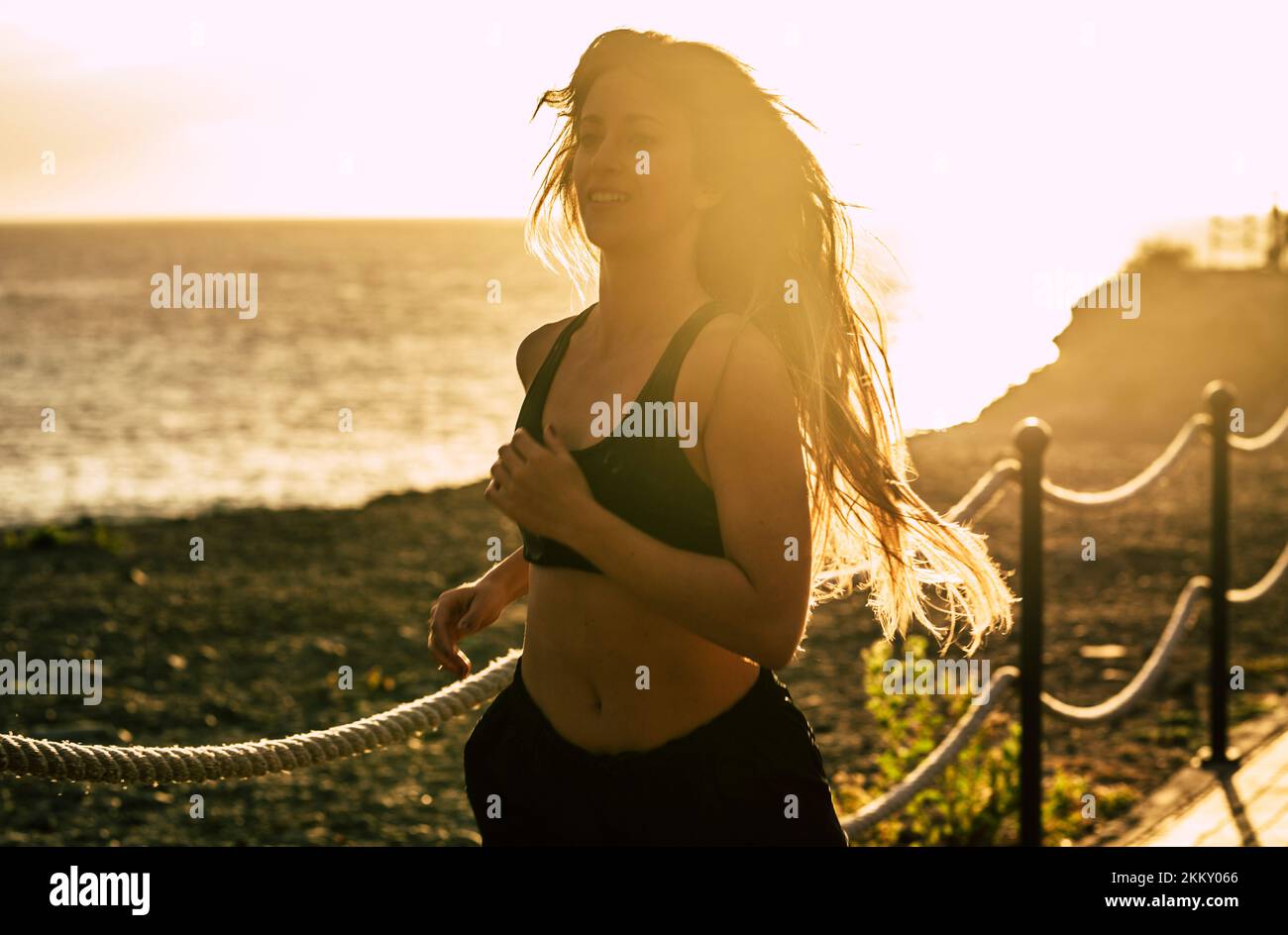 One young and healthy woman run outdoor for fitness exercise lifestyle, Morning running routine for active people. Sunset and ocean view in background Stock Photo
