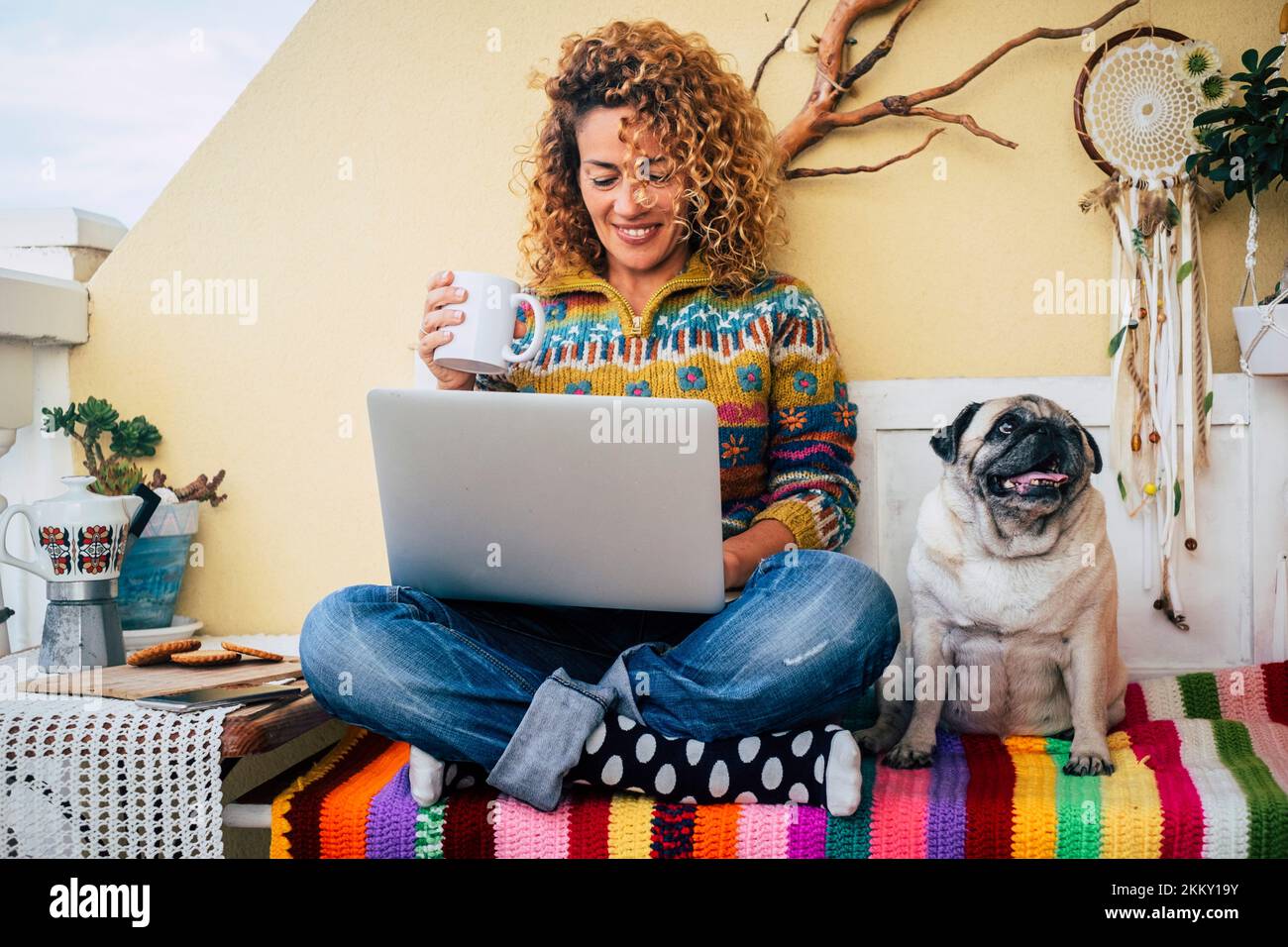 People and dog best friends forever together. One happy woman smile and use laptop sitting near her lovely friend companion dog pug. Animal and busine Stock Photo