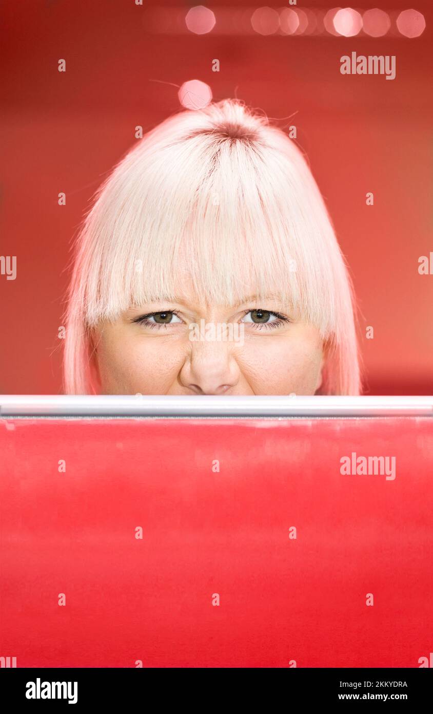 An Irate Female Worker Peers Over An Office Partition Into The